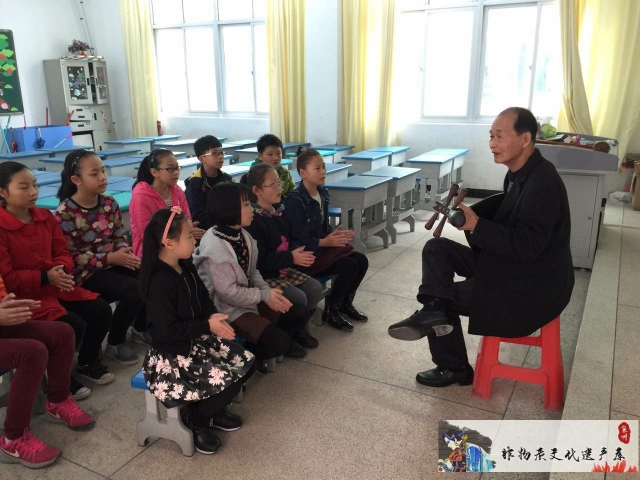 图4：丁则友（右一）进入校园传授南音（2014年，陈埭紫峰中心小学），著作权人及手机号：丁春风13505051919