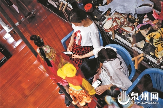 排练比较枯燥，休息时，年轻人喜欢静静地看一会儿手机。