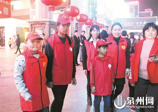来自广西的周仙仙（中后）与儿子（中前）与其他志愿者一起在商城广场巡逻，为有需要的市民提供服务。（陈明华 摄）