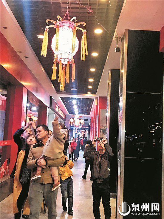 陈华的朋友一家子在新门街赏花灯，感受泉州元宵盛况。（王金植 摄）